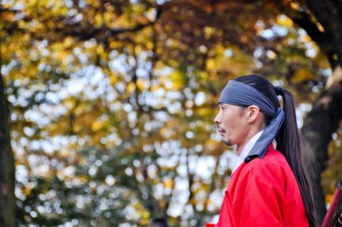 SEOUL, Güney Kore - 23 Ekim 2022: Geleneksel Kore Krallığı Asker Savaşçısı Namsan Dağı 'ndaki sonbahar yaprakları arasında nöbet tutuyor