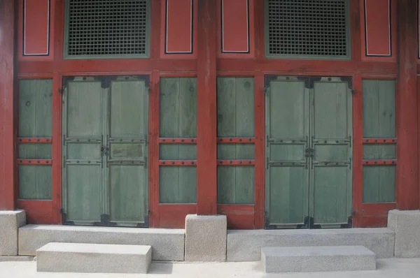 韓国の古代宮殿の建物の壁の伝統的な木製の赤褐色と緑のドア — ストック写真