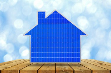 Bulanık mavi gökyüzü arkaplanındaki güneş panellerinden yapılmış ev