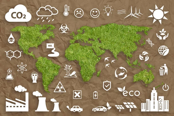 Ecology concept: sustainable World. A green grass textured World map above a brown crumpled paper sheet, with several white ecology icons superimposed on background.