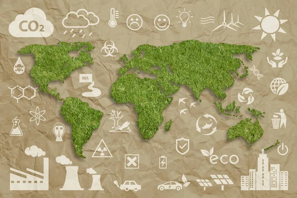 Ecology concept: sustainable World. A green grass textured World map above a brown crumpled paper sheet, with several white ecology icons superimposed on background.