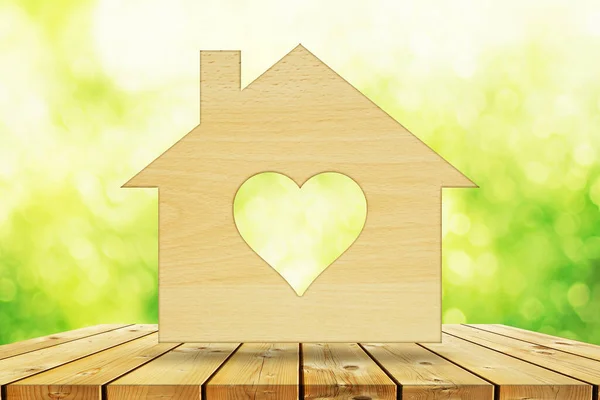 stock image Ecology concept, sustainable house. House silhouette with heart shape on wooden wall