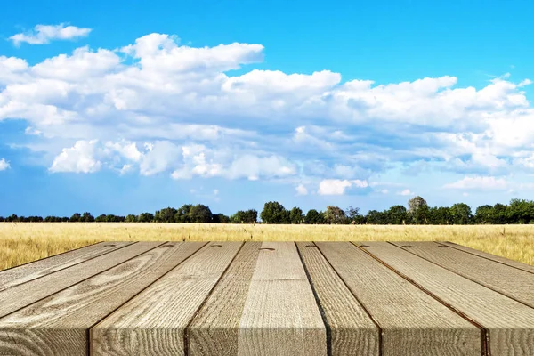 Ecology background: a brown empty wood planks table on natural blue sky landscape background.