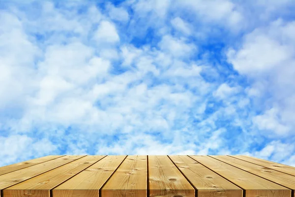 Ecology background: empty wood planks desk on blue sky background.