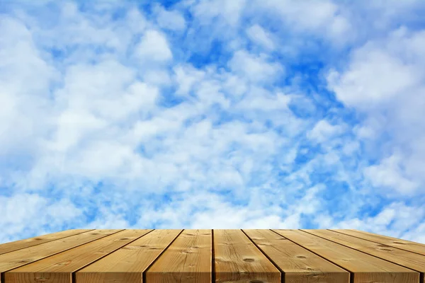 Ecology background: empty wood planks desk on blue sky background.