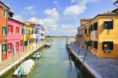 Burano kartpostalı. Burano adasının renkli evleri. Güneşli bir günde Venedik Eyaleti, Veneto Bölgesi, Kuzey İtalya 'da balıkçı tekneleri ile dar su kanallarının temel seti üzerine çok renkli binalar.. 