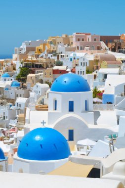 Yunanistan 'ın Santorini adasındaki Oia köyü. Caldera, Cyclades adaları üzerinde mavi kubbeleri olan geleneksel ve ünlü evler ve kiliseler Ege Denizi.