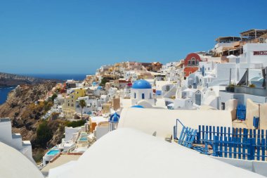Yunanistan 'ın Santorini adasındaki Oia köyü. Caldera, Cyclades adaları üzerinde mavi kubbeleri olan geleneksel ve ünlü evler ve kiliseler Ege Denizi.