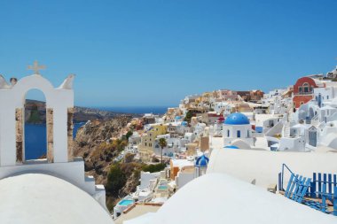 Yunanistan 'ın Santorini adasındaki Oia köyü. Caldera, Cyclades adaları üzerinde mavi kubbeleri olan geleneksel ve ünlü evler ve kiliseler Ege Denizi.
