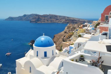 Yunanistan 'ın Santorini adasındaki Oia köyü. Caldera üzerinde mavi kubbeli geleneksel ve ünlü evler ve kiliseler, Cyclades adaları Ege Denizi.