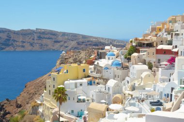 Yunanistan 'ın Santorini adasındaki Oia köyü. Caldera, Cyclades adaları üzerinde mavi kubbeleri olan geleneksel ve ünlü evler ve kiliseler Ege Denizi.