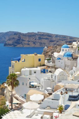 Yunanistan 'ın Santorini adasındaki Oia köyü. Caldera, Cyclades adaları üzerinde mavi kubbeleri olan geleneksel ve ünlü evler ve kiliseler Ege Denizi.