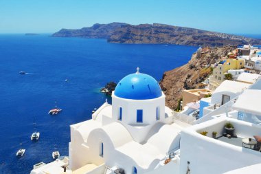 Yunanistan 'ın Santorini adasındaki Oia köyü. Caldera, Cyclades adaları üzerinde mavi kubbeli ve beyaz evleri olan geleneksel ve ünlü kilise Ege Denizi. 