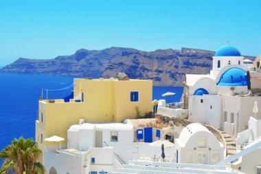 Yunanistan 'ın Santorini adasındaki Oia köyü. Caldera üzerinde mavi kubbeli geleneksel ve ünlü evler ve kiliseler, Cyclades adaları Ege Denizi.
