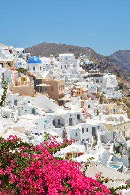 Yunanistan 'ın Santorini adasındaki Oia köyü. Caldera üzerinde mavi kubbeli geleneksel ve ünlü evler ve kiliseler, Cyclades adaları Ege Denizi.