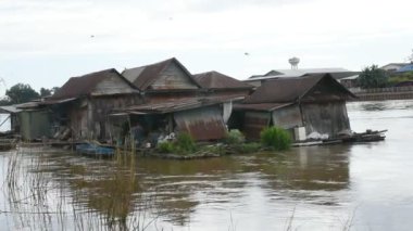 Tayland 'da Nakhonsawan şehrinde hızlı akan akıntıyla Chao Phraya ve Ping nehrinde yüzen terk edilmiş bir ev ya da hasar görmüş bir rafthouse.