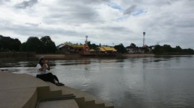 Gezgin Taylandlı kadınlar Pa San veya Pasan köprüsünü ziyaret eder ve Chao Phraya nehir kenarında Chao Pho Thepharak Mae Thapthim Çinli tanrıça tapınağı Nakhon Sawan Tayland 'da fotoğraf çekerler.