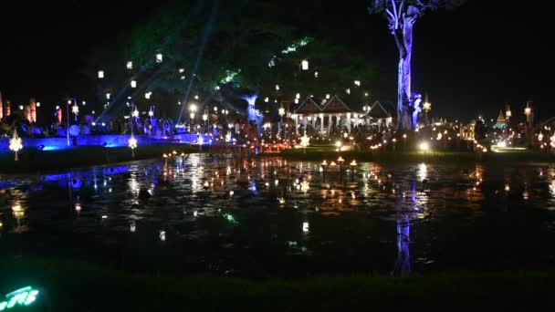 タイの人々や外国人旅行者の訪問は タイのスコータイ歴史公園で花火やパオテイン ファイやバーニング キャンドルを演奏し 火災を再生ロイ クラトンとキャンドル祭りを見て — ストック動画