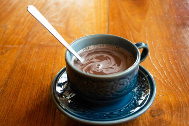 Gezginler için seramik cam bardakta servis edilen sıcak ovaltine çikolatalı kakao. İnsanlar dinleniyor. Bangkok, Tayland 'daki kafe restoranında yiyip içiyorlar.