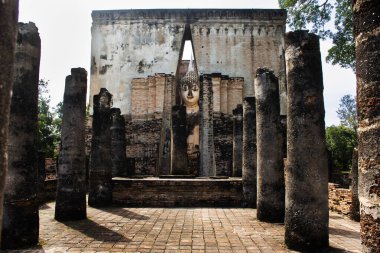 Wat Si Chum Tapınağı ve antik Pra Ajana Buddha heykellerinin antik harabeleri Tayland 'ın Sukhothai kentindeki Sukhothai Tarihi Park Dünya Mirası sahasında dua ederek seyahat ediyorlar.