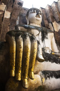 Wat Si Chum Tapınağı ve antik Pra Ajana Buddha heykellerinin antik harabeleri Tayland 'ın Sukhothai kentindeki Sukhothai Tarihi Park Dünya Mirası sahasında dua ederek seyahat ediyorlar.