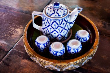 Tayland 'ın Suphan Buri şehrinde Song Phi Nong şehrindeki açık kafe ve restoranın yemeklerini içen Taylandlı müşterilere çay saati için hazırlanmış antika seramik çaydanlık.