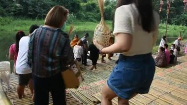 Taylandlı yabancı gezginler, 5 Kasım 2022 'de Ratchaburi Tayland' da Suan Phueng şehrindeki yerel pazar pazarında dua ve sadaka verme geleneğine katılırlar.