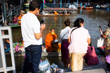 Taylandlı gezginler, 8 Kasım 2022 'de Nonthaburi Tayland' da Wat Sai Yai kanalında Keşiş alayı için yapılan törenlere katılıp dua ediyorlar.