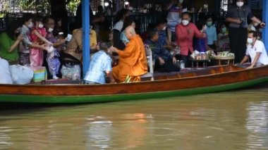 Taylandlı gezginler, 8 Kasım 2022 'de Nonthaburi Tayland' da Wat Sai Yai kanalında Keşiş alayı için yapılan törenlere katılıp dua ediyorlar.