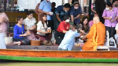 Taylandlı gezginler, 8 Kasım 2022 'de Nonthaburi Tayland' da Wat Sai Yai kanalında Keşiş alayı için yapılan törenlere katılıp dua ediyorlar.