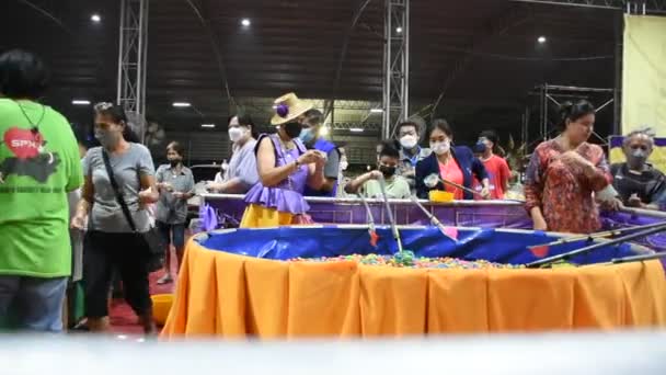 タイの旅行者のためのラッキードローの卵スクープゲームタイの人々のための訪問を旅行し ノンタブリタイのワットプラサート寺院で開催されたLoi Krathongイベントフェスティバルで買い物をするギャンブラーリスクを再生するためのチケットを購入する — ストック動画