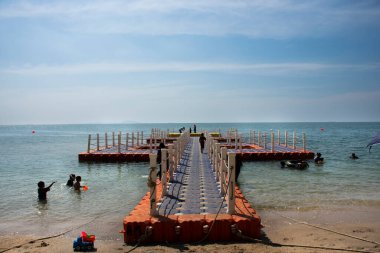 Taylandlılar ve yabancı gezginler 8 Kasım 2022 'de Chon Buri' de, Tayland 'ın Chonburi kentinde, Bangsaen Sahili' nde plastik dubalarla kum ve yüzme dalgası okyanusu ziyaret ederler.