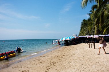 Taylandlılar ve Taylandlılar için plaj şemsiyesi ve mobilya 8 Kasım 2022 'de Chonburi, Tayland' da Bangsaen Sahili 'nde deniz kenarında yüzmek arasında dinleniyor.