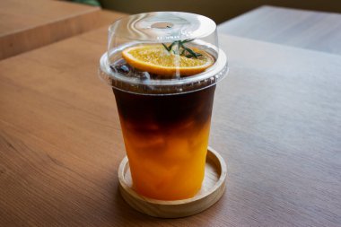 Portakal suyu ve plastik cam bardakta buzlu espresso sade kahve. Tayland, Bangkok 'taki klasik kafe kafeteryasında gezginler yiyip içiyor.