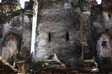 Ancient antique broken buddha statue and ruin damage old chedi stupa for thai people travel visit respect praying blessing holy mystery in Wat Choeng Tha pagoda or Koy Tha temple in Ayutthaya Thailand