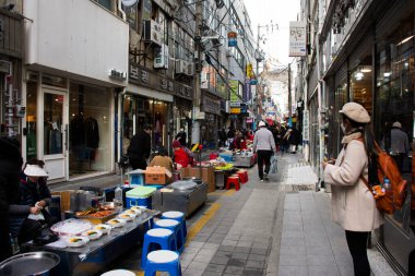 Yerel işportacılar, 18 Şubat 2023 'te Güney Kore' nin Busan kentindeki Nampo dong veya Gwangbok dong 'a gidip içki içen gezginler için sokak yemekleri pazarındaki geleneksel Kore gurmesini oyalıyor.