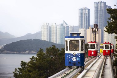 Korean people and foreign travelers sitting passengers journey on Sky Capsule Tram Haeundae Blue Line at Mipo Station for travel visit at Haeundae Beach Park on February 18, 2023 in Busan, South Korea clipart