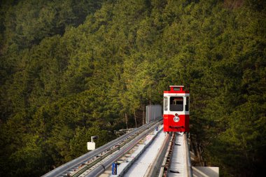 Güney Kore 'nin Busan kentindeki Haeundae Gu şehrindeki Haeundae Sahil Parkı' nda seyahat için Mipo İstasyonu 'ndaki Gökyüzü Kapsülü Tramvayı' nda seyahat eden Koreli ve yabancı yolcular.