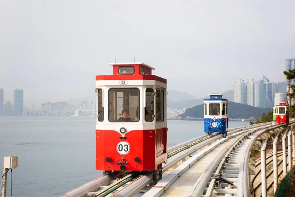 Koreli ve yabancı yolcular 18 Şubat 2023 'te Güney Kore' nin Busan kentindeki Haeundae Sahil Parkı 'na seyahat için Mipo İstasyonu' ndaki Gökyüzü Kapsülü Tramvayı Tramvayı ile seyahat ediyorlar.