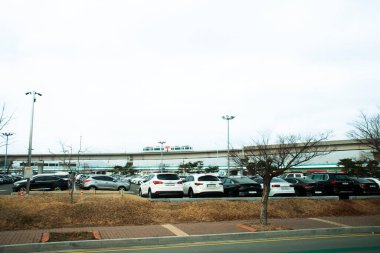 18 Şubat 2023 'te Busan, Güney Kore' de, Gimhae Uluslararası Havaalanı 'nda, Koreliler ve yabancı yolcular, araç parkında durur.