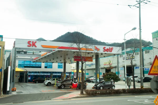 韓国人と外国人旅行者は2023年2月18日に韓国の釜山で路上交通路で自転車に乗る韓国人のガソリンスタンド生活様式の車のタンクに油を充填します — ストック写真