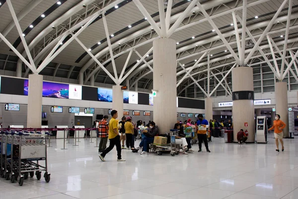 Koreli ve yabancı yolcular, 18 Şubat 2023 'te Jeju Uluslararası Havalimanı Jeju Adası, Güney Kore' deki seyahat yolculuğunda kontrol için terminalde bavullarını taşıyorlar.