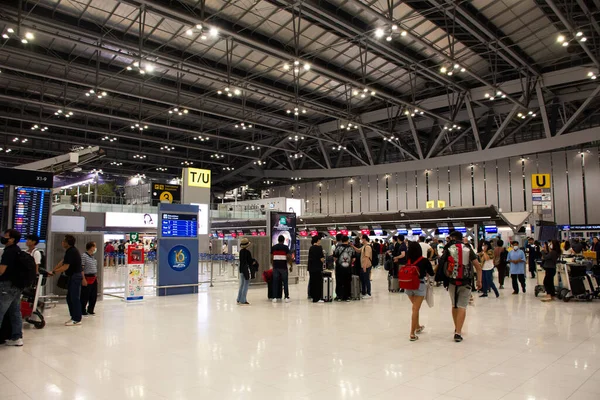 タイ人と外国人旅行者2023年2月16日にタイのバンコクでスワンナプーム国際空港での旅行の訪問の旅でチェックするためにターミナルで手荷物を運ぶ歩いて乗客 — ストック写真