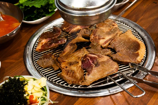 在韩国 当地传统的韩国风味食品济州岛的黑猪烧烤烤肉和韩国人的调味配菜吃当地餐馆的酒菜 — 图库照片