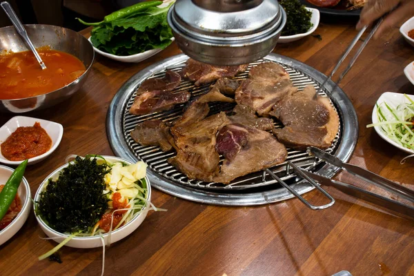 韓国の伝統的な韓国料理済州島の黒豚の焼き肉と韓国人の調味料サイドディッシュ韓国で地元のレストランでドリンク料理を食べる ストックフォト
