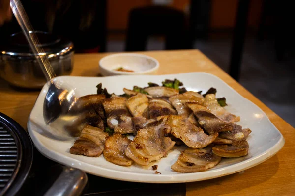 韓国の伝統的な韓国料理済州島の黒豚の焼き肉と韓国人の調味料サイドディッシュ韓国で地元のレストランでドリンク料理を食べる — ストック写真