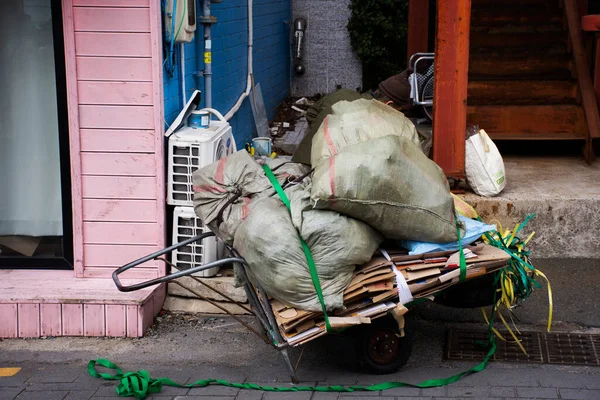 stock image Life and lifestyle of korean worker people keep pickup trash recyclable waste garbage on cart and push tri bicycle on street road in Gamcheon Culture Village at Pusan city in Busan, South Korea