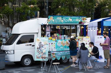 Taylandlılar ve yabancı gezginler 25 Şubat 2023 'te Bangkok Tayland' daki Iregaram mağazasında festival fuarında yemek yemek için yemek kamyonundan alışveriş yapıyorlar.