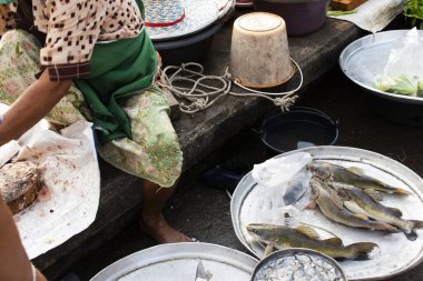 Taylandlı balıkçılar için taze su satışı gezginler için taze su balığı. Tayland, Phatthalung 'daki Saen Suk Lampam Plajı' nda sabah saatlerinde yerel sokak pazarından alışveriş ürünleri satın alıyorlar.