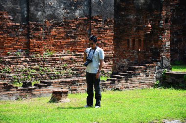 Taylandlı fotoğrafçı gezginler seyahat eder ve dijital kamerayla antik harabeleri çekerler. Wat Phra Rattana Mahathat 'ın antik mimarisi Lop Buri, Tayland' da Lopburi şehrinde.